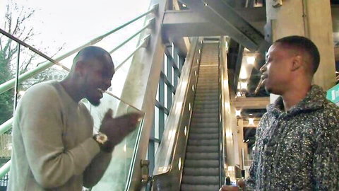 Two Black men in casual clothes talking on urban escalator, preview for BBC rough sex scene