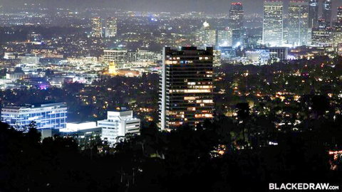 Little Dragon overlooks glittering LA skyline at night in erotic cityscape view