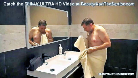 Senior man in towel after shower in steamy spa bathroom