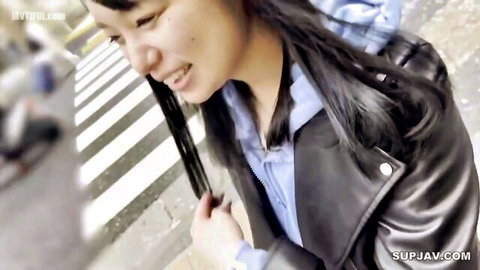 Sexy Asian H-cup babe in blue top and leather jacket at outdoor POV tease