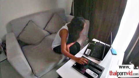 Thai teen with small tits sitting casually on couch in tank top