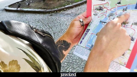 Antony Carter points at map in casual tourist outfit with tattoo