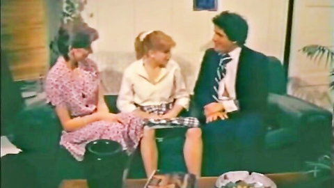 Vintage taboo threesome with two clothed brunettes in dresses teasing suited man on couch