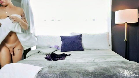 Skinny tattooed trans brunette with big hard cock teasing by exposing dick under white sheet on bed