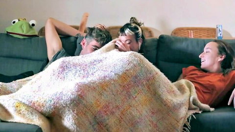 Skinny young babes tease threesome cuddle with guys under blanket on couch