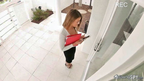 Blonde nanny in tight skirt and cleavage-exposing blouse checks phone while holding red folder