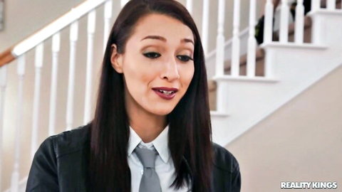Seductive young brunette with long hair and medium tits smirks in white shirt and tie on stairs