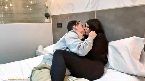 Amateur couple passionately kissing on bed, girlfriend in leggings and top