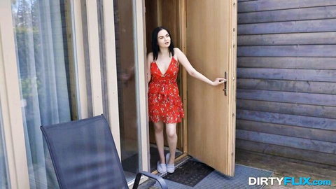 Brunette in skimpy red floral mini dress standing at garden door entrance