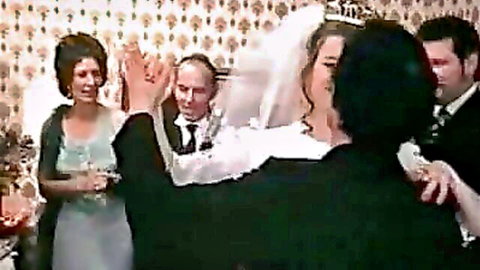 Vintage wedding bride in white gown toasts champagne with groom and guests in retro scene