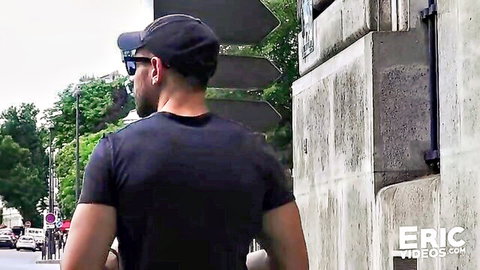 Handsome man in black cap and sunglasses walking down urban street