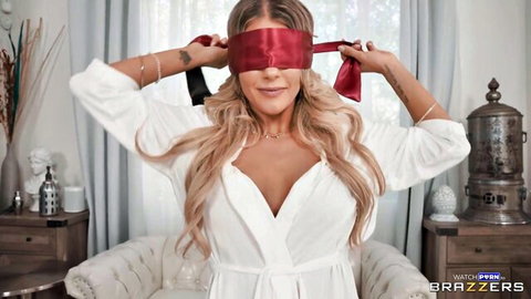 Tattooed blonde MILF in open white robe teasing with red blindfold