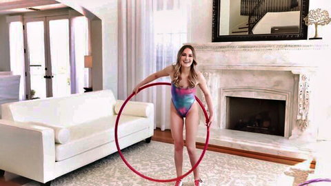 Skinny redhead teen in tiny multicolored bikini holds red hula hoop teasing small tits and ass