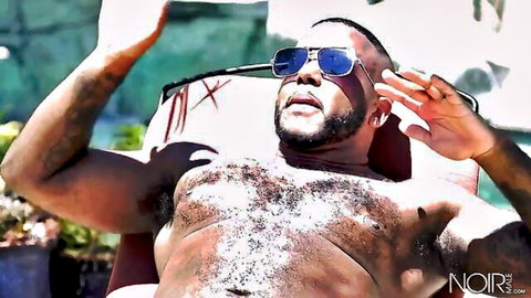 Muscular black man lounging poolside, shirtless hairy chest, beard and blue sunglasses