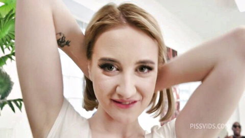 Daruma Rai blonde exotic model smiling with arms raised in white tank top