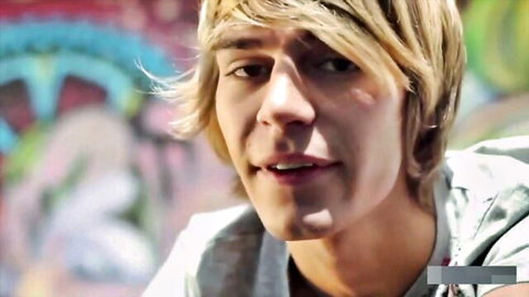 Smiling blonde twink in hoodie against colorful graffiti, teasing bareback anal action