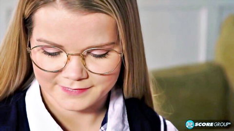 Lexxxus Adams smiling close-up in glasses and schoolgirl uniform