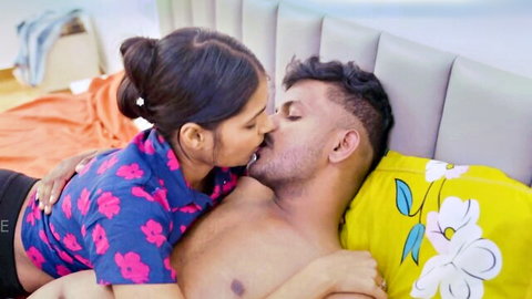 Indian girlfriend passionately kissing shirtless boyfriend on bed straddling him steamy