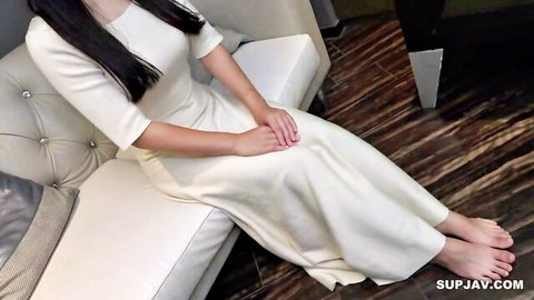 Young Asian babe with long black hair in elegant white dress, bare feet tease