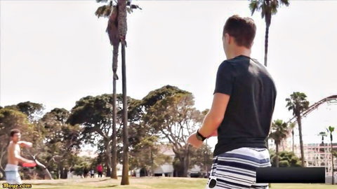 Two athletic men in swim trunks outdoors, teasing hot gay threesome