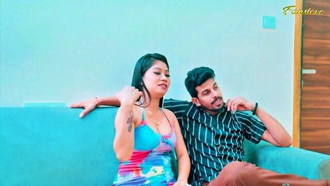Sexy Indian babe in tight colorful top flirts intimately with handsome guy on blue couch