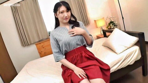 Naughty Asian girl in gray blouse and red skirt teases on bed flashing white panties and deep cleavage