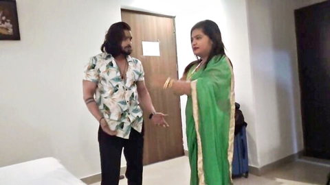 Indian couple in hotel room, boyfriend in floral shirt grabs plump girlfriend in green saree intensely