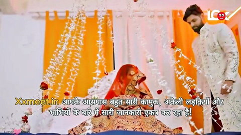 Desi Indian bride in red bridal veil with groom in wedding attire, suhagraat scene