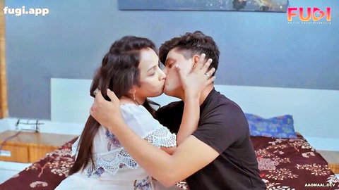 Busty Indian stepmom in lace dress passionately kissing young man on bed