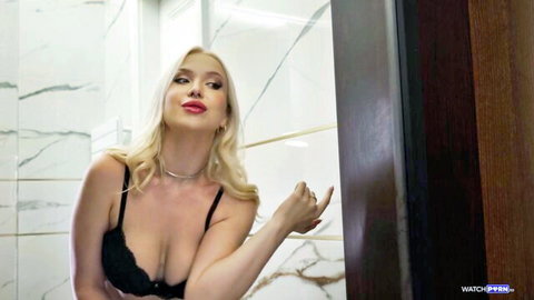 Seductive blonde with huge tits in black lace bra teases with puckered lips in marble bathroom.