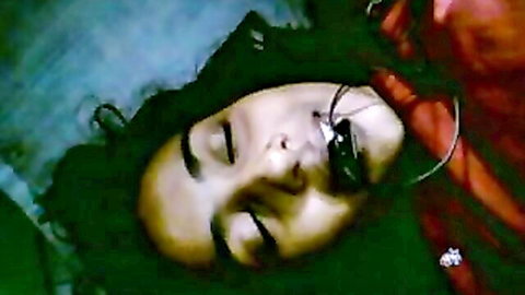 Closeup of sexy Indian woman's face with black gag in mouth lying down