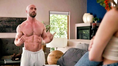 Buff bald muscular hunk flexing ripped abs in tight white shorts for babe on bed