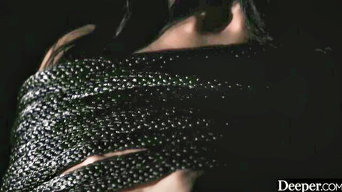 Brunette with massive tits bursting from sparkly black dress in seductive dark pose