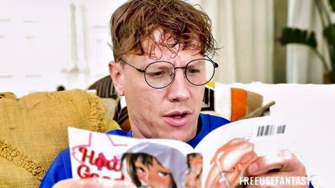 Ginger guy with glasses shocked reading open hentai manga with big anime tits exposed