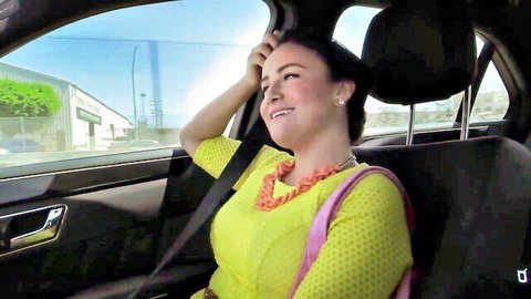 Curvy brunette smiling in yellow dress while riding in car