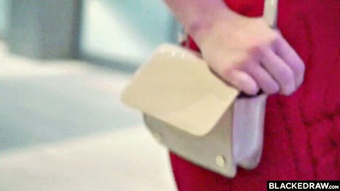 Blonde woman in tight red dress holds beige clutch purse teasingly closeup