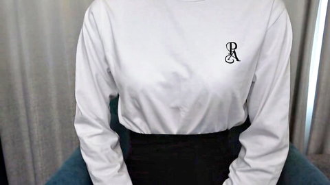 Cute girl in white sweater with PR logo and tiny black skirt sits teasingly on chair during audition