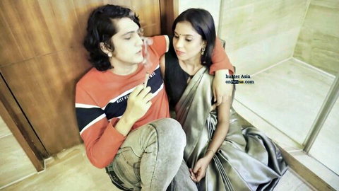Indian boyfriend and girlfriend cuddle intimately on living room floor in saree desi couple