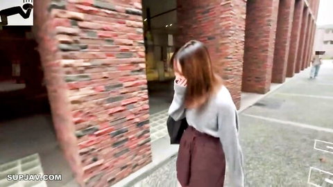 Nervous Asian woman in grey sweater and maroon skirt, first time on camera excitement