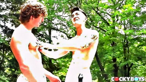 Two muscular shirtless studs playfully tweaking nipples outdoors in woods