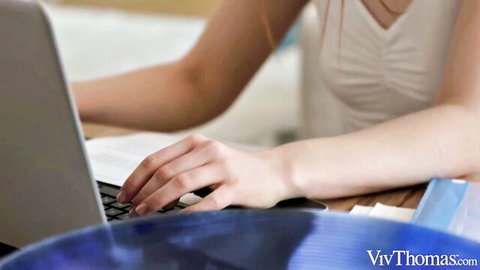 Sandra Wellness typing on laptop in sexy white office top
