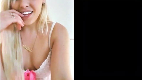 Lola Taylor blonde in white lace lingerie, smiling with cleavage tease