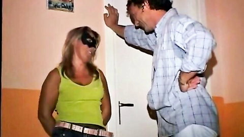 Blonde blindfolded babe in tank top teased by man in hallway, wild orgy teaser