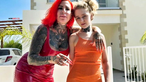 Tattooed redhead Cat-Coxx hugs blonde MaryjaneAuryn in sexy dresses outdoors