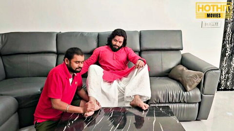 Indian sarpanch in kurta receives foot worship from villager in red shirt