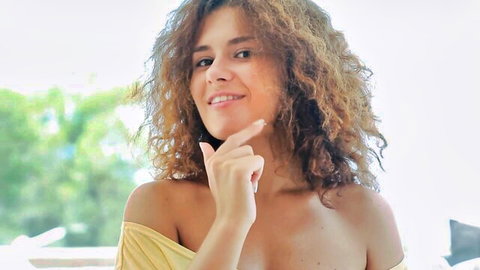Koni Demiko teases with smile in yellow off-shoulder top