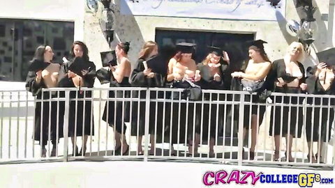 Topless college grads flashing big bare tits under open gowns at graduation behind fence
