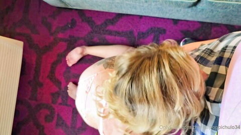 Blonde woman lying on purple rug in open plaid shirt and pink top with bare feet visible