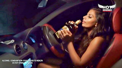 Hot Indian babe with big cleavage drinks beer seductively in car driver's seat