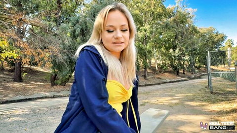 Blonde Blake in yellow top and blue hoodie outdoors in park teaser
